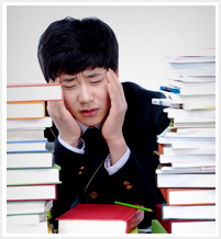 쌓여있는 책들 앞에서 머리아파하는 학생의 이미지