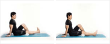 남성이 매트에 앉아 한쪽 다리를 펴고 발을 몸쪽으로 당기고 있다.
