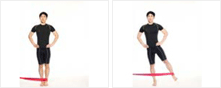 남성이 탄력밴드를 한쪽 발목에 걸고 옆으로 서서 바깥쪽으로 당기고 있다.